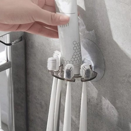 Vægmonteret tandbørsteholder med sugekopper og opbevaring til tandpasta, egnet til badeværelset.