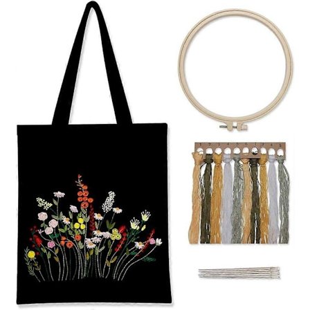 Broderisett på svart lerret med mønster og instruksjoner, inkluderer en broderiveske med blomstermønster, broderirammer i bambus, C-tråder