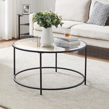 Pyöreä sohvapöytä lasitasolla ja mustalla teräsrungolla