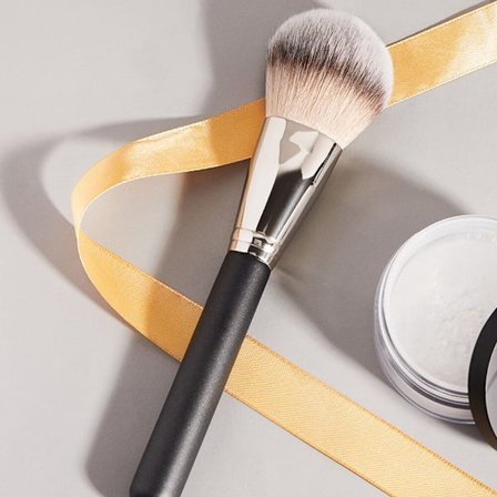 En svart puderborste för nybörjare i en endelsdress