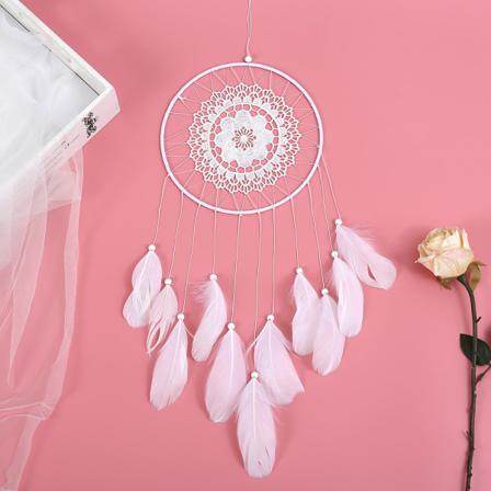 Valkoinen hanhenhöyheninen unensaalija suurella leijuvalla pitsillä