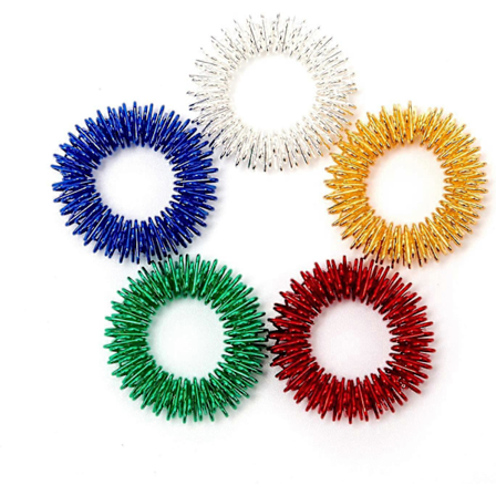 Pakkaus, jossa 5 piikikästä aisti-akupainanta hierontasormusta, hiljainen Grand Fidget -aistilelu 2024THO