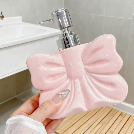 Bows-formet sæbedispenserflaske, egnet til dispensering af shampoo, body wash og håndsæbe i badeværelset; en husholdningsartikel.