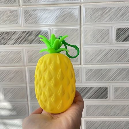 Ananas-formet møntpung lavet af blødt materiale, som også fungerer som nøglering opbevaringspose. Dens bærbare design og realistiske udseende gør den.