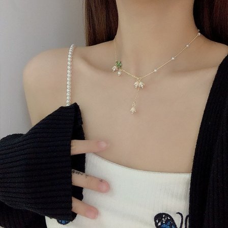 Halsband med vita liljekonvaljer och tofsar