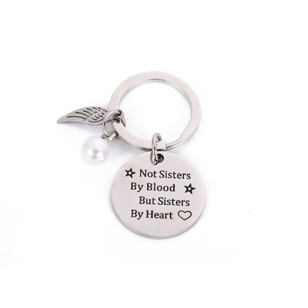 Nøglering med vinge og tag med teksten "Sisters by Heart"