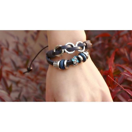 Brunt läderarmband med dekorationer och ringar