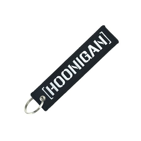 En sort racer nøgle med broderet tekst og personlig nøglering