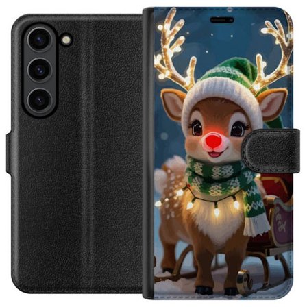 Samsung Galaxy S24+ Tegnebogsetui Festlig rensdyr med glødende horn, rød næse og strikket grøn hue står foran slæden i et sneklædt miljø og sp