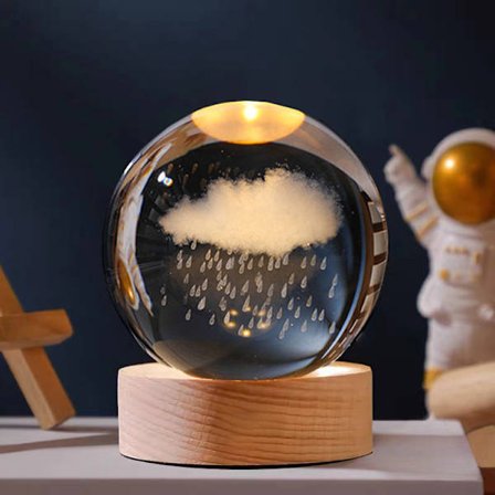 Kreativ krystallkule med rund lysende base utskåret på innsiden, regnsky