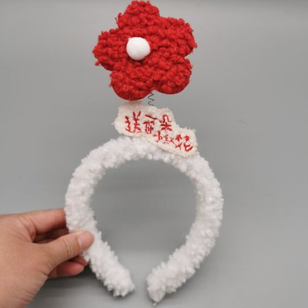 Skickar dig ett litet pannband med röd blomma