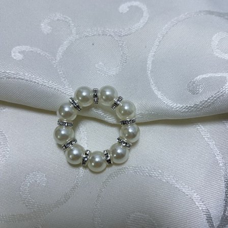 Valkoiset tekohelmi- ja metalliset lautasliinarenkaat kirkkailla koristekivillä