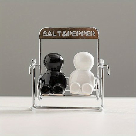 Et elegant sett med sorte og hvite keramiske salt- og pepperkverner, med et moderne design og metallbase, perfekt for dekorasjon.