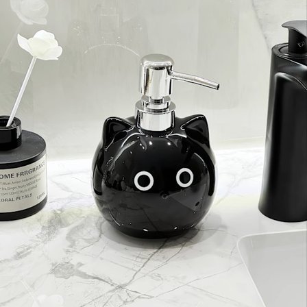 Keraamisessa lotion-pullossa on pyöreäsilmäinen musta kissa -design.