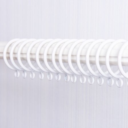 En uppsättning av 20 vita metallgardinringar för gardinstänger, med en i