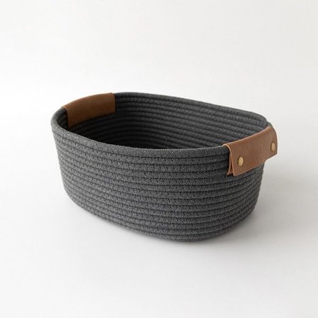 Liten bomullskurv med PU-lærhåndtak for oppbevaring av baby- og barneklær, leker, godteri og gaver. Laget av bomullstau, den er for stuen