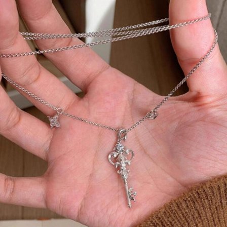 Damhalsband med vintage-nyckel och lilja, silverkedja, eleganta detaljer.